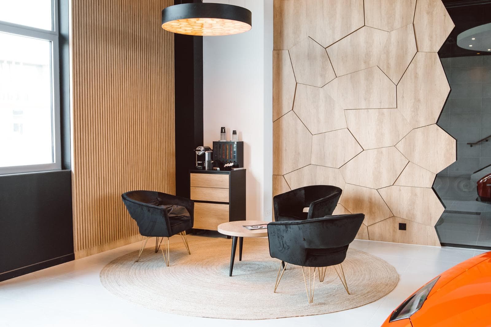 Zona de estar com painel de parede hexagonal e ripado em madeira