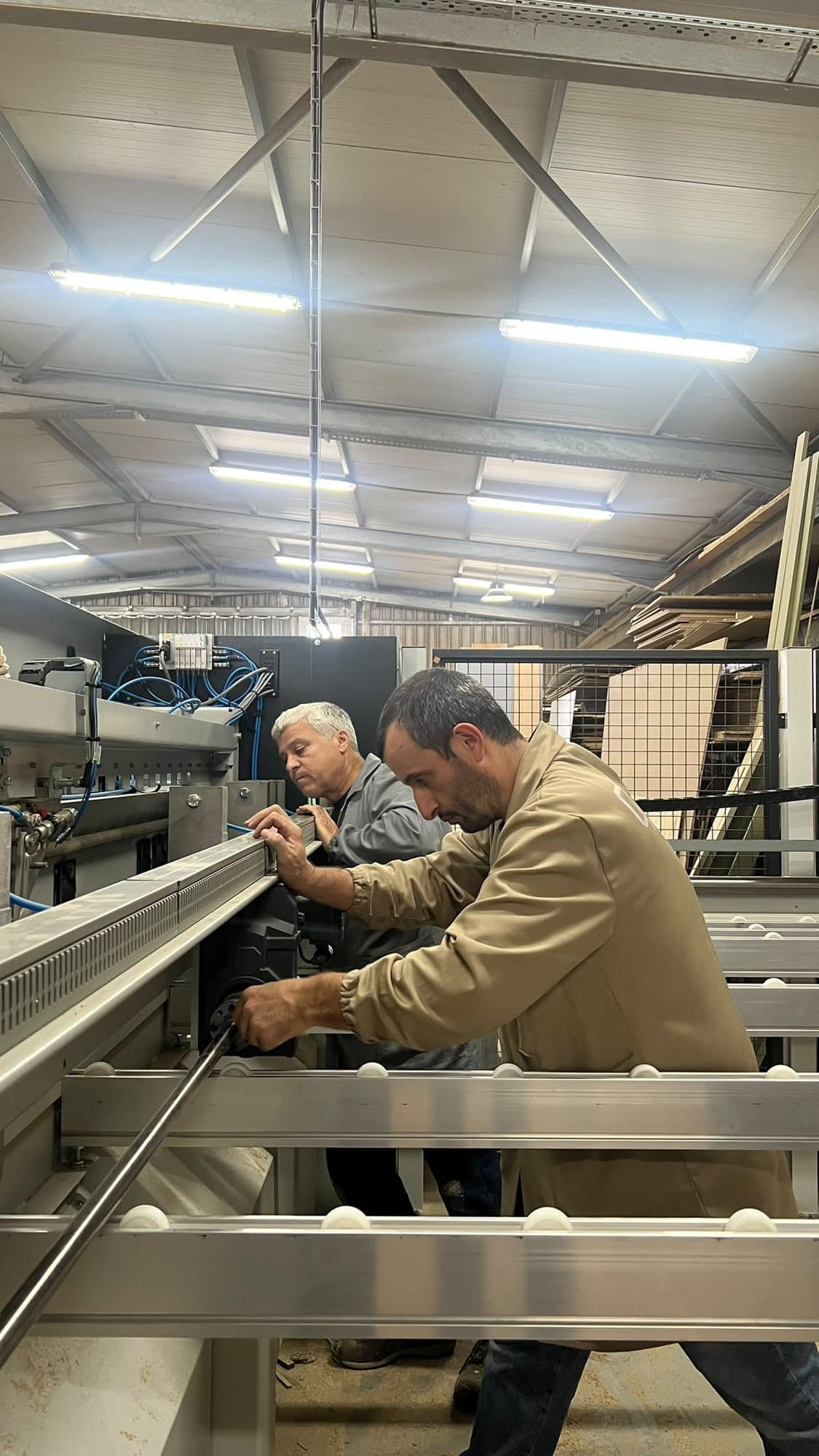 Dois carpinteiros da QS a operar uma máquina de produção