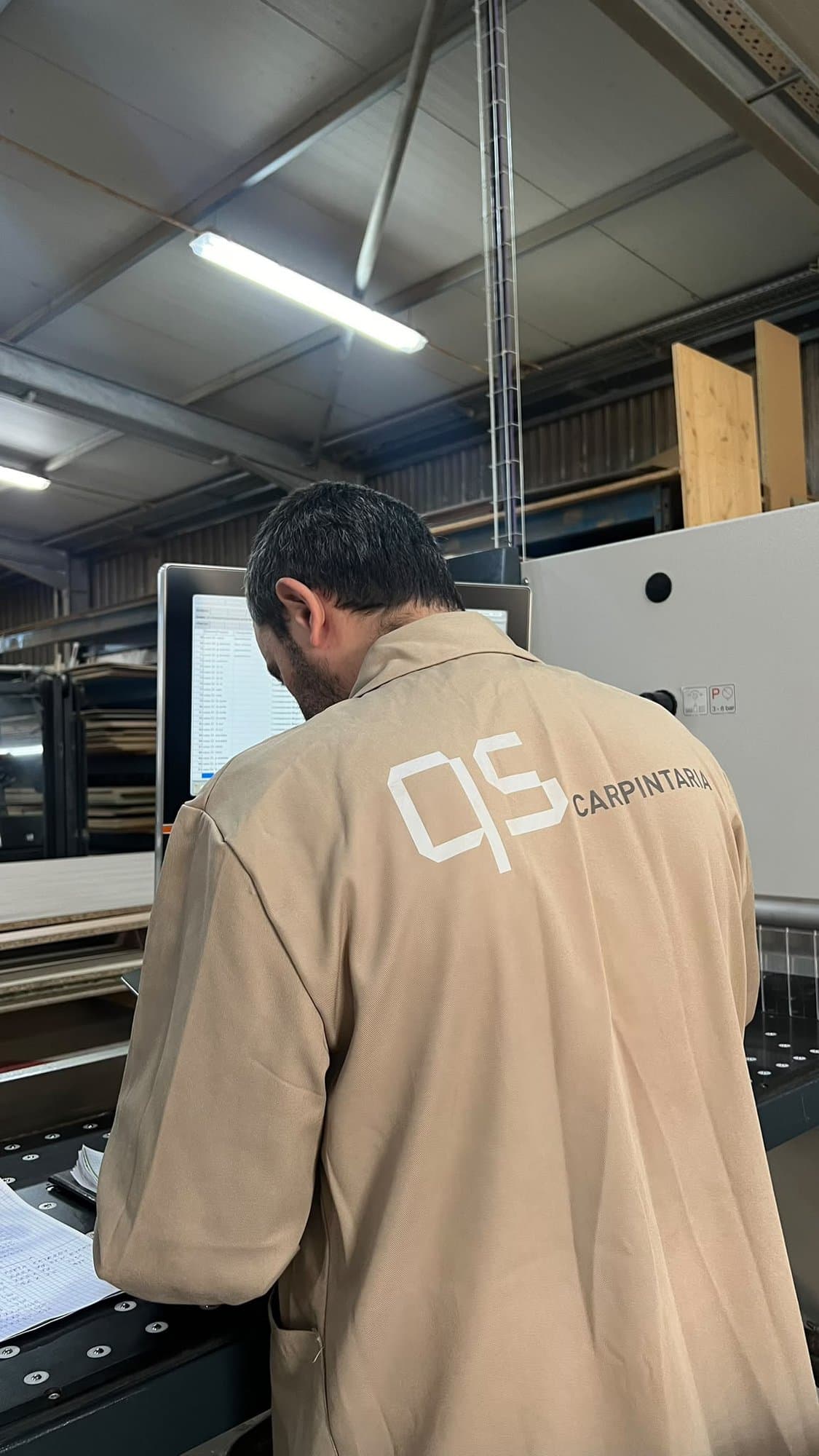 Membro da equipa QS Carpintaria a trabalhar numa máquina na oficina
